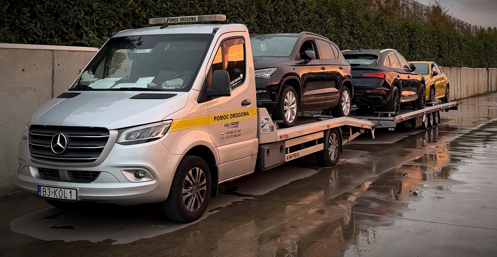 Srebrna laweta Mercedes-Benz Sprinter Kol-Trans z przyczepą i czterema samochodami załadowanymi w Belgii o poranku